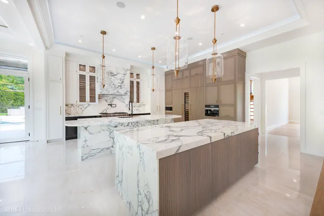 a kitchen with stainless steel appliances granite countertop a stove a sink a refrigerator and a wooden floor