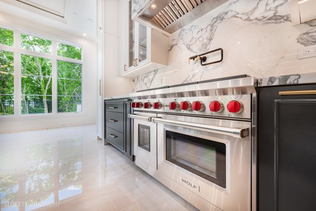 a large kitchen with stainless steel appliances granite countertop a stove and refrigerator