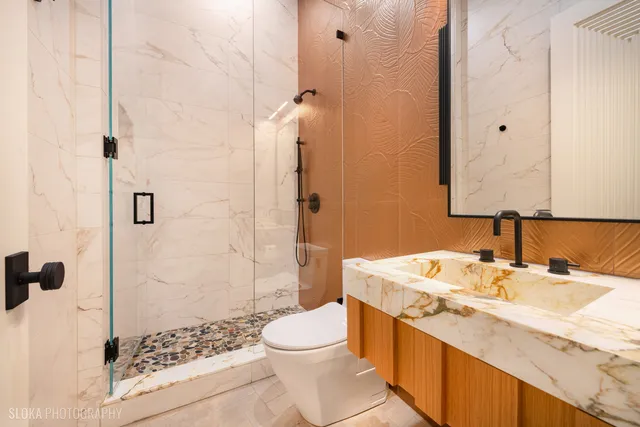 a bathroom with a granite countertop sink a large mirror and a shower