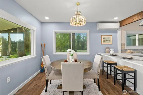 a view of a dining room with furniture a rug and wooden floor