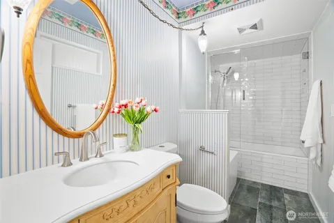 a bathroom with a sink a toilet and a mirror