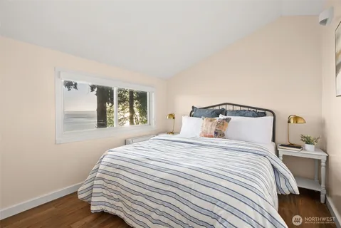 a bedroom with a bed and a painting on the wall