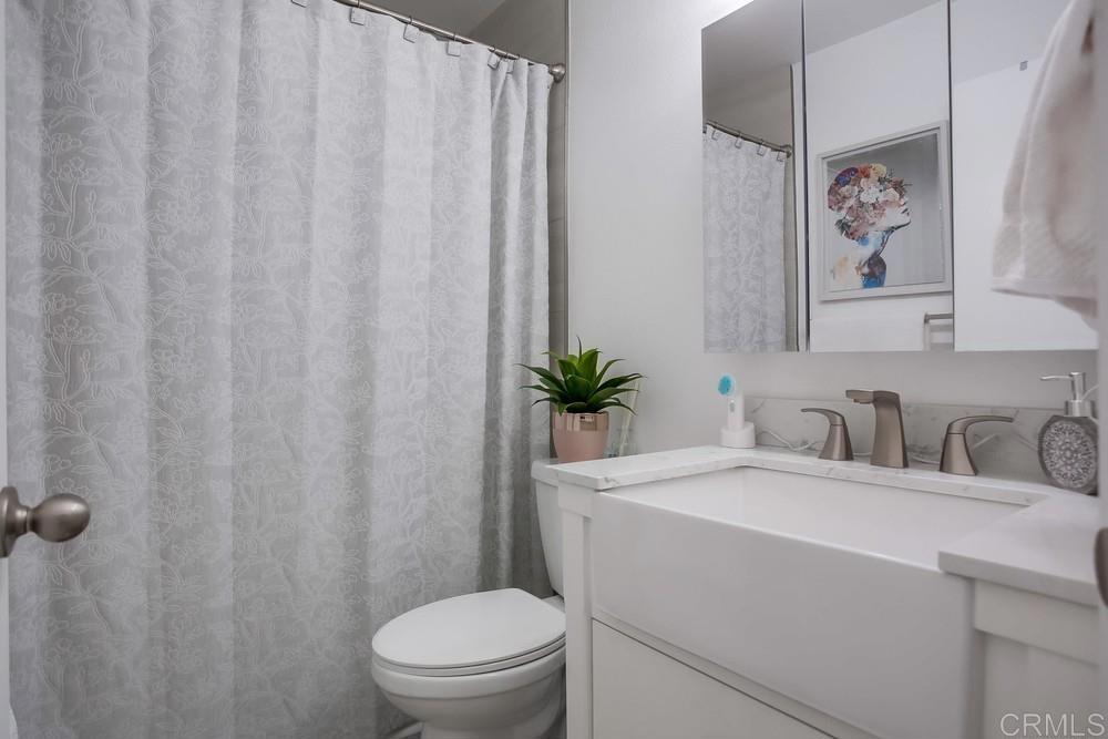 2630 Pirineos Way, Unit 11 Carlsbad, CA 92009 - Photo 21 of 28 a bathroom with a sink a toilet and a mirror