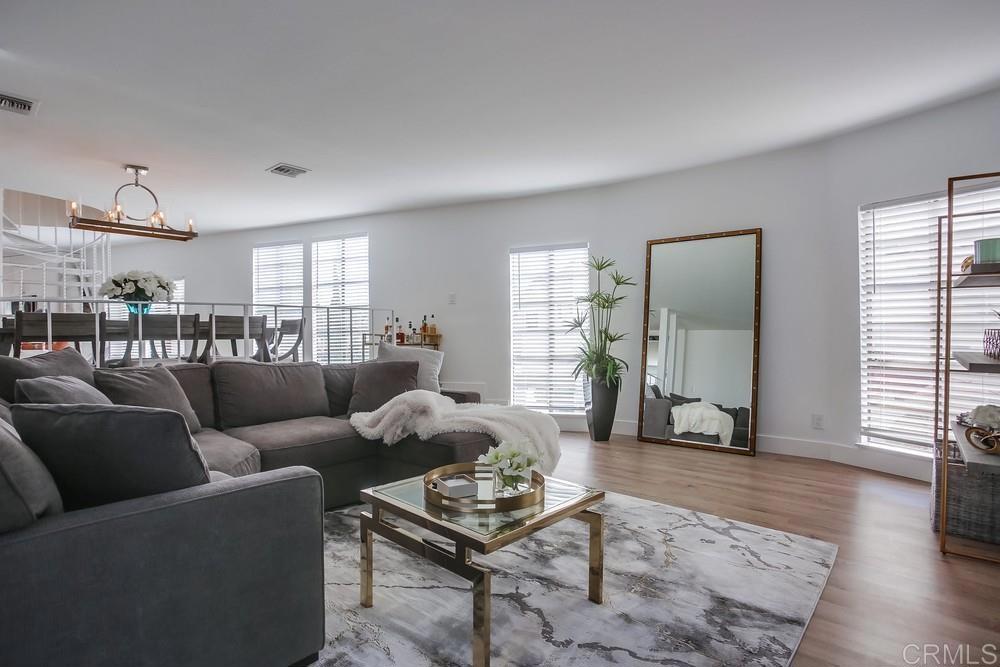 2630 Pirineos Way, Unit 11 Carlsbad, CA 92009 - Photo 3 of 28 a living room with furniture and wooden floor