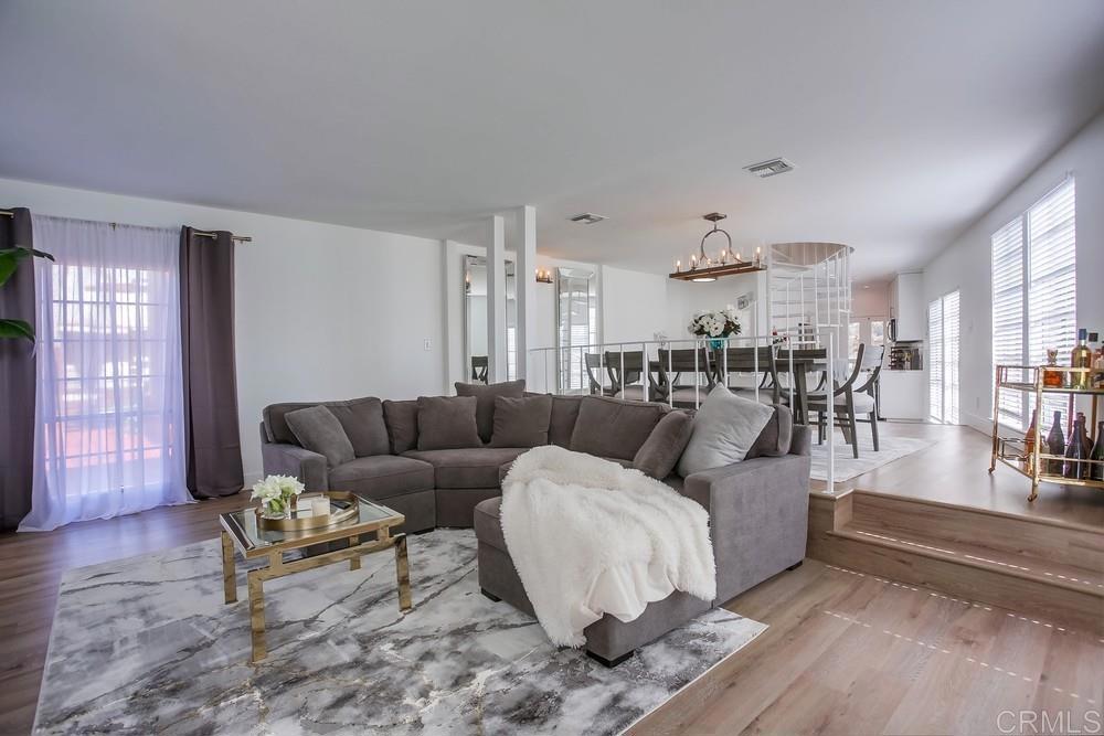 2630 Pirineos Way, Unit 11 Carlsbad, CA 92009 - Photo 4 of 28 a living room with furniture and wooden floor