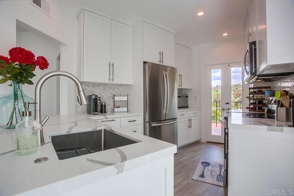 2630 Pirineos Way, Unit 11 Carlsbad, CA 92009 - Photo 6 of 28 a kitchen with stainless steel appliances a refrigerator sink and cabinets