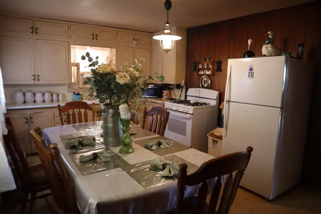 a kitchen with refrigerator a dining table and chairs