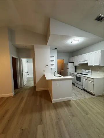 a kitchen with a sink cabinets and wooden floor