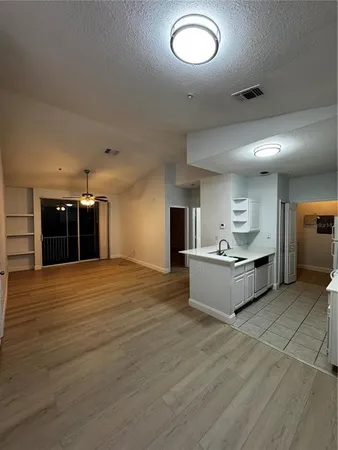 a living room with kitchen furniture and a wooden floor