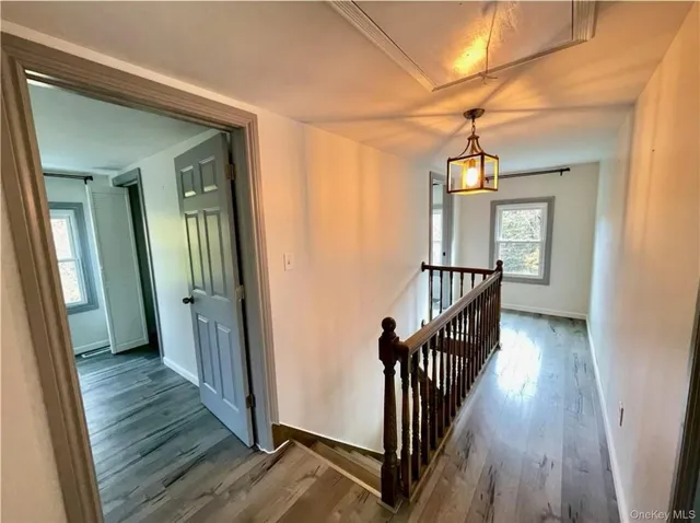 a view of a hallway with wooden floor and stairs