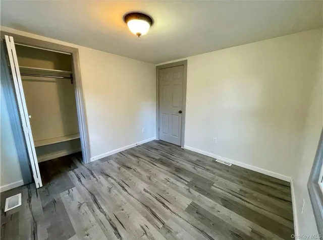 an empty room with wooden floor and closet