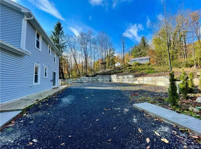 a view of a yard with plants and a building