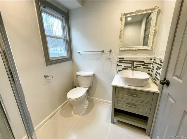 a bathroom with a toilet a sink and a mirror