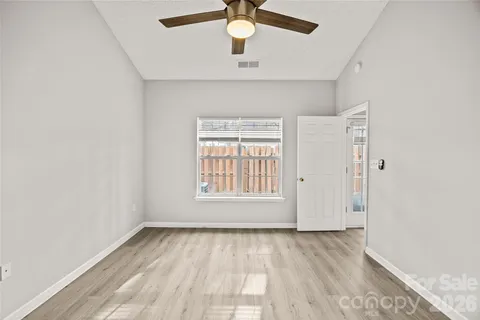 an empty room with a window and a ceiling fan