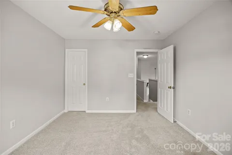 a view of an empty room and chandelier fan
