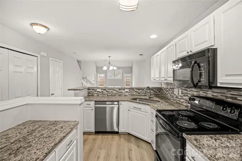 a kitchen with stainless steel appliances granite countertop a stove a sink and a microwave