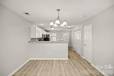 a view of a kitchen with wooden floor and a large window