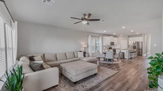 a living room with furniture kitchen view and a window
