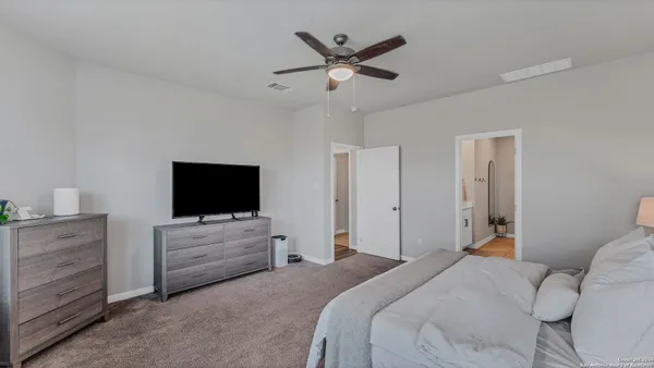 a bedroom with bed tv and window