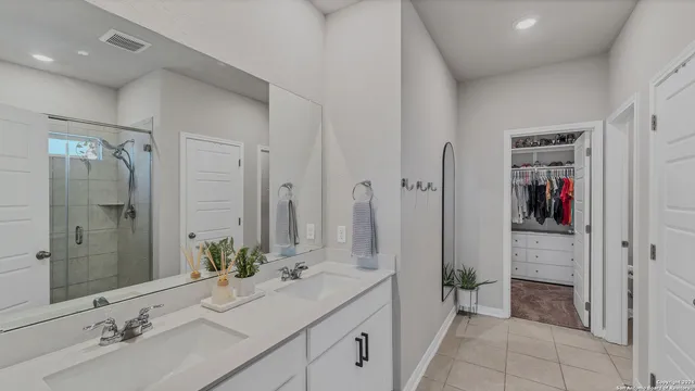 a spacious bathroom with a shower sink and mirror
