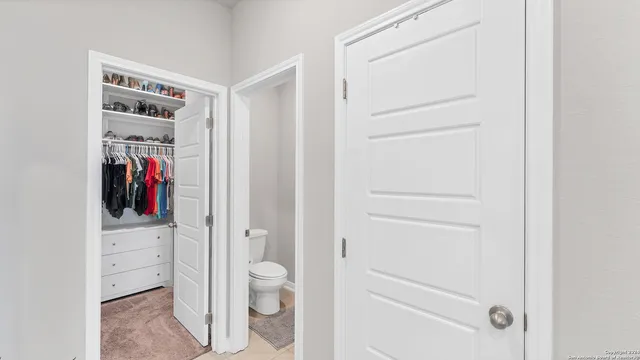 a view of walk in closet with clothes and shoes