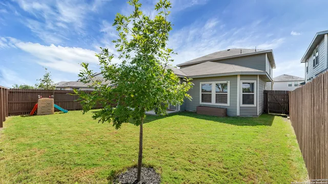 a backyard of a house with table and chairs