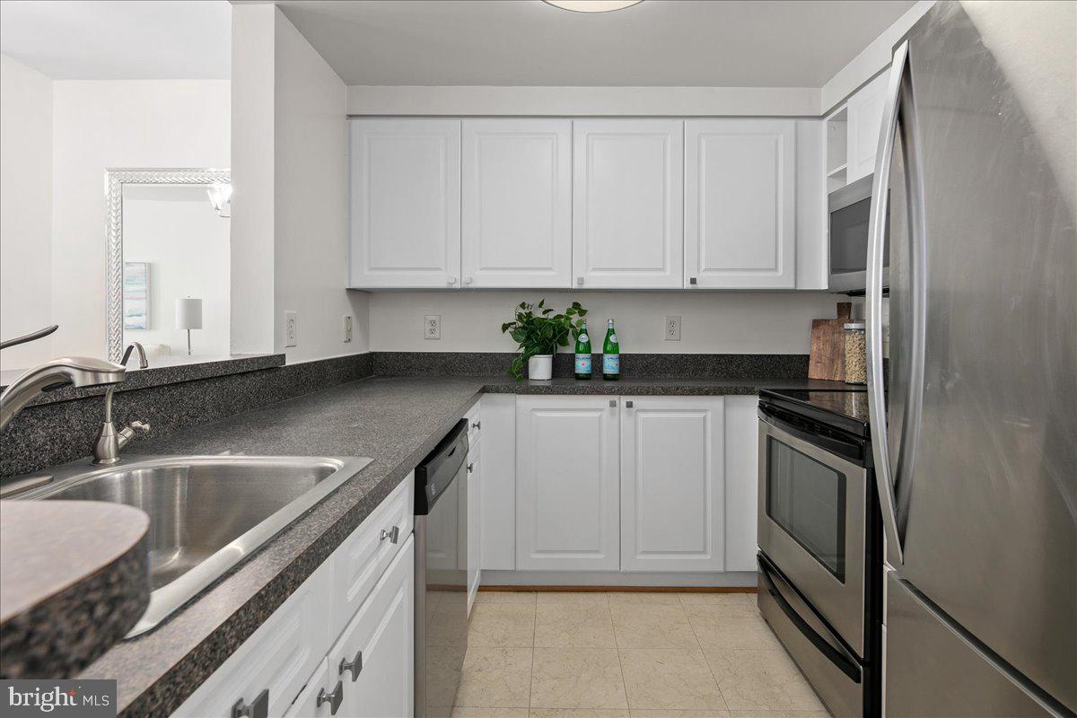 1312 Massachusetts Avenue Northwest, Unit 710 Washington, DC 20005 - Photo 15 of 30 a kitchen with granite countertop a sink stove and cabinets