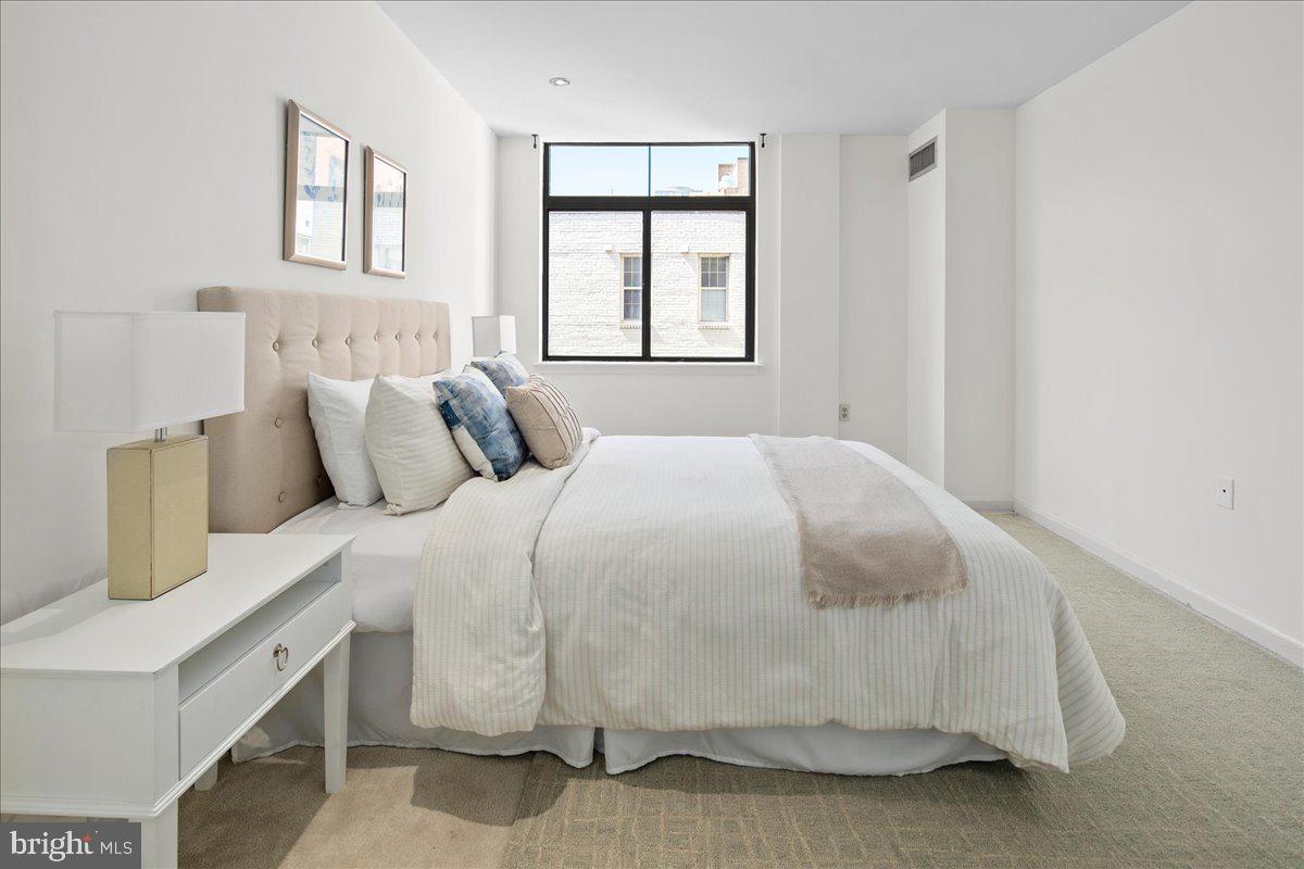 1312 Massachusetts Avenue Northwest, Unit 710 Washington, DC 20005 - Photo 21 of 30 a bedroom with a bed and a window
