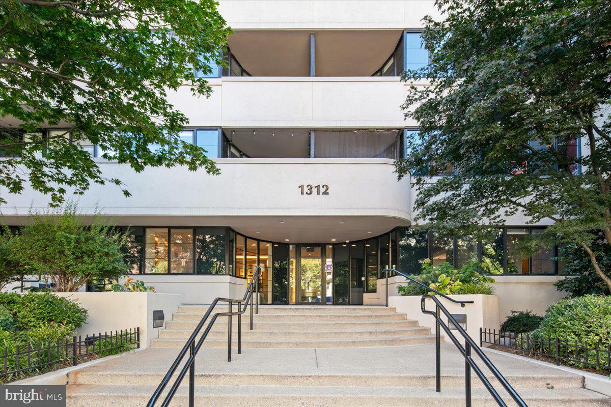 1312 Massachusetts Avenue Northwest, Unit 710 Washington, DC 20005 - Photo 24 of 30 a view of a patio with table and chairs under an umbrella with wooden fence
