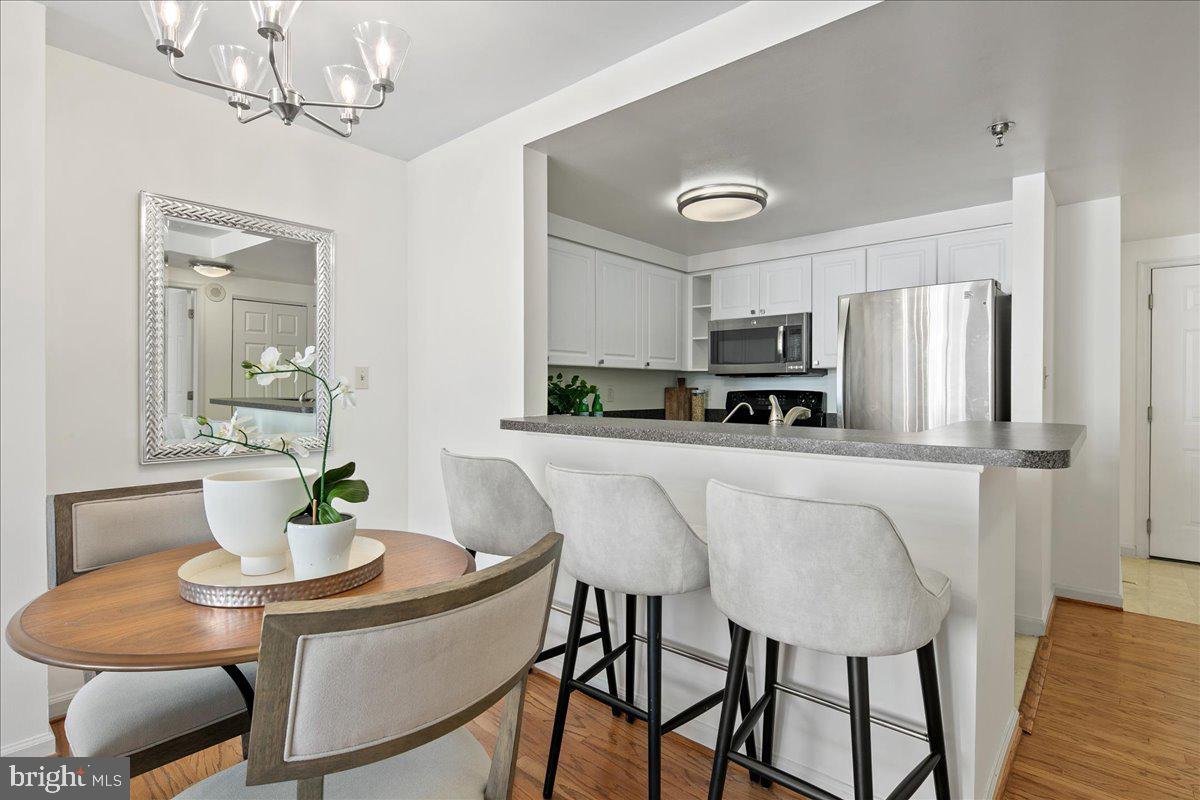 1312 Massachusetts Avenue Northwest, Unit 710 Washington, DC 20005 - Photo 10 of 30 a kitchen with stainless steel appliances a table and chairs