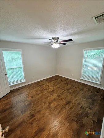 a view of a room with wooden floor and white walls