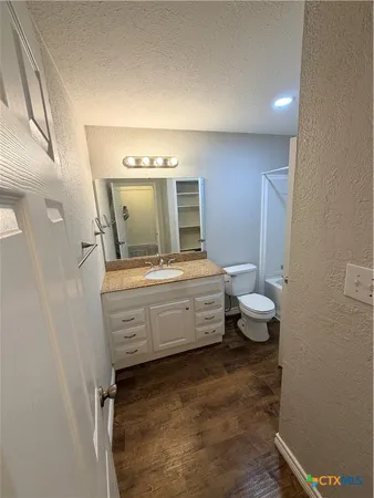a bathroom with a granite countertop sink toilet and shower