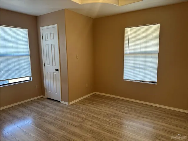 a view of empty room with wooden floor
