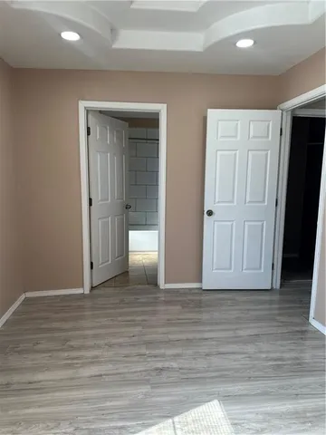 an empty room with wooden floor & closet area