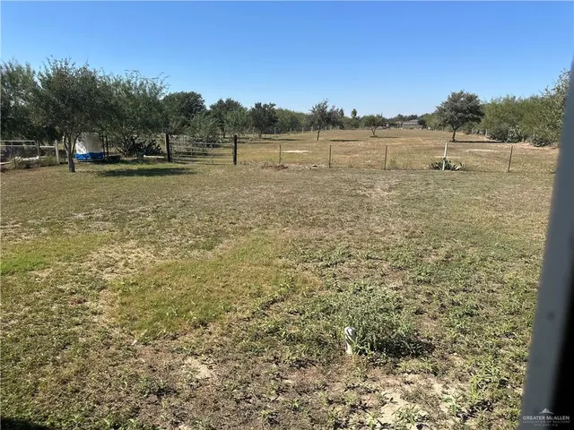 a view of a field with trees in the background