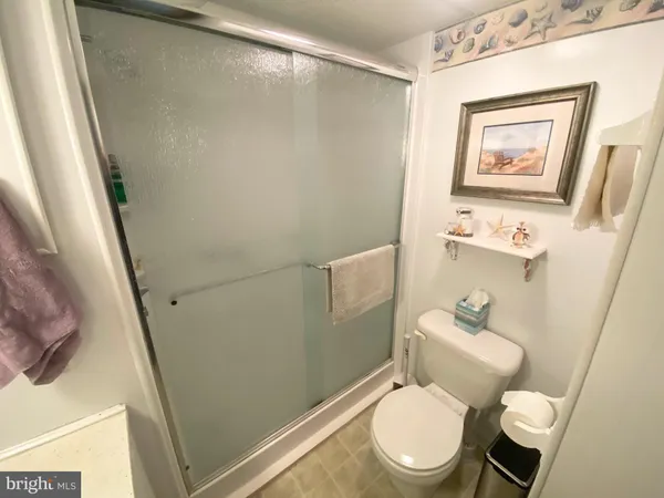 a white toilet sitting next to a bathroom sink and a mirror