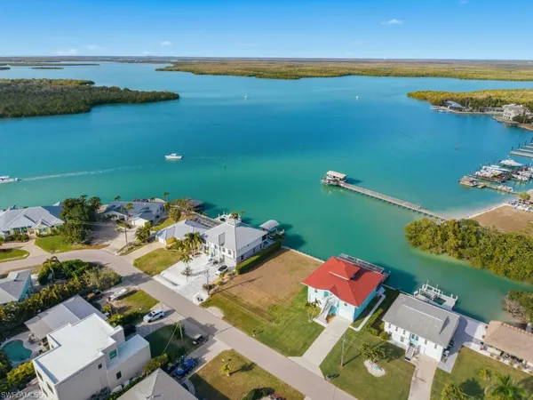 an aerial view of ocean and residential houses with outdoor space