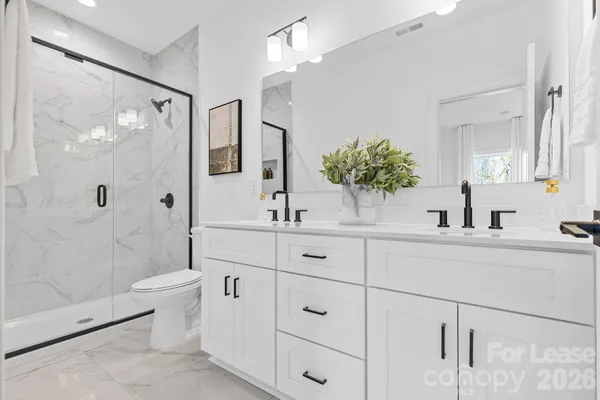 a bathroom with a double vanity sink toilet and shower