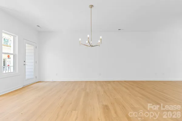 a view of a room with wooden floor and white walls