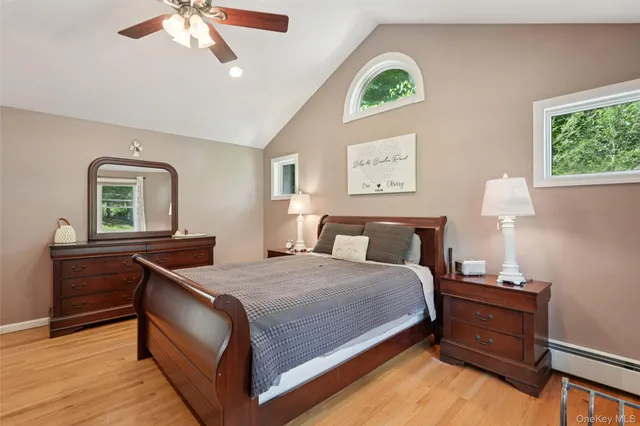 a bedroom with a bed and a dresser next to a window