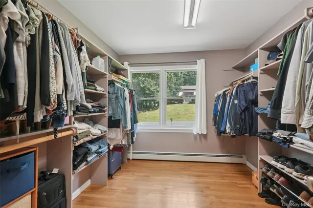 a view of walk in closet with clothes and shoes