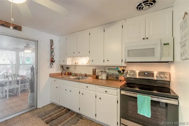 a kitchen with granite countertop white cabinets and stainless steel appliances