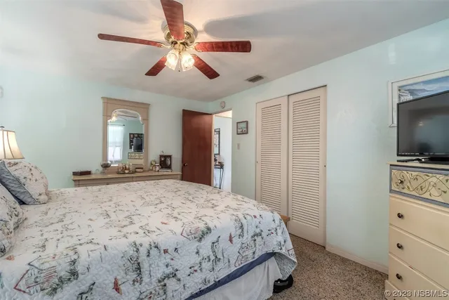 a spacious bedroom with a bed and a flat screen tv