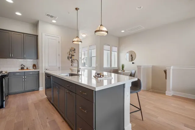 a kitchen with granite countertop a sink cabinets and wooden floor