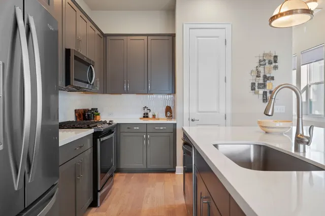 a kitchen with stainless steel appliances granite countertop a sink stove and refrigerator