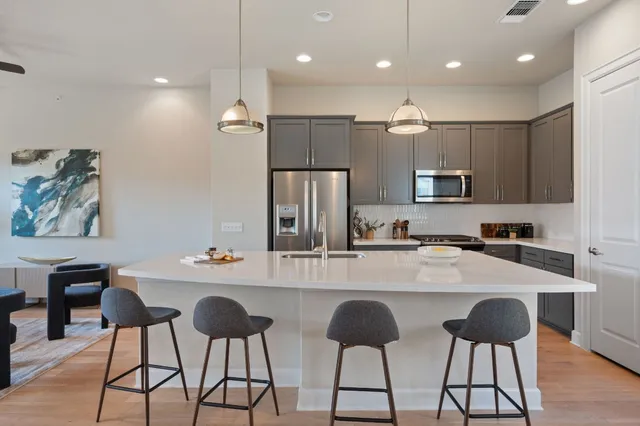 a kitchen with kitchen island granite countertop a sink and refrigerator