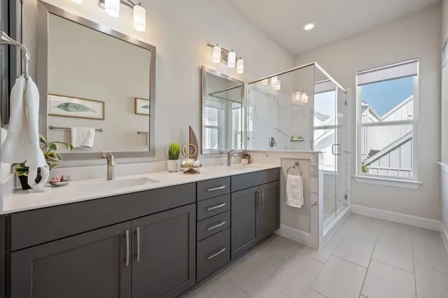 a spacious bathroom with a double vanity sink a mirror and a shower