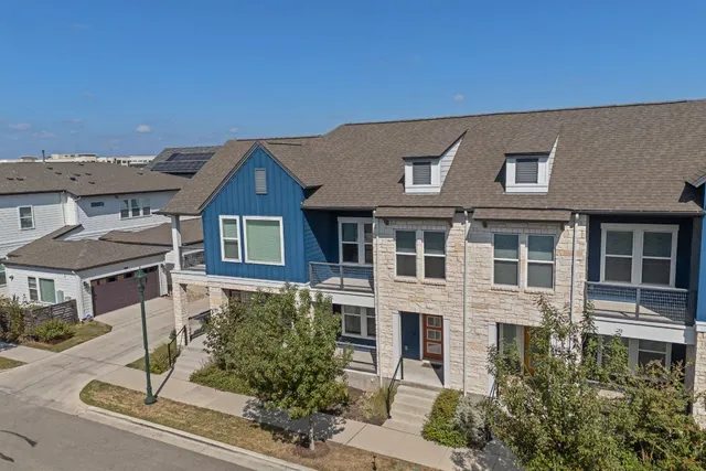 a aerial view of a brick house next to a yard