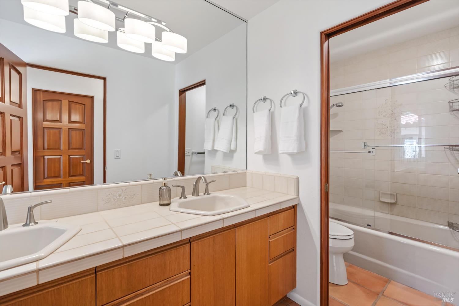 4800 Skycrest Way Santa Rosa, CA 95405 - Photo 27 of 38 Main hall bathroom with dual sinks and tiled shower over tub.