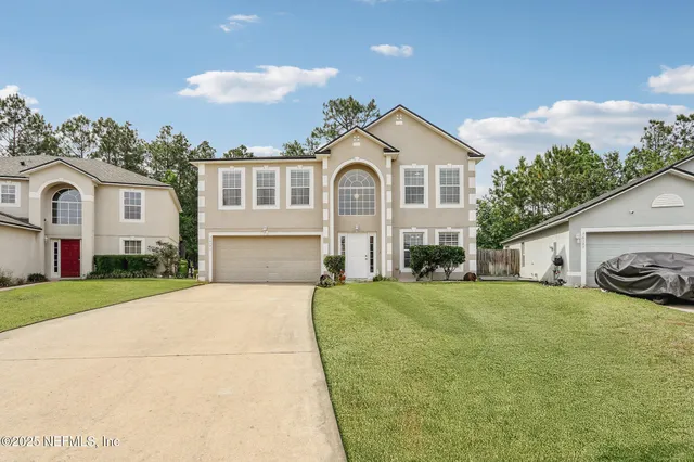 a front view of a house with a yard and garage